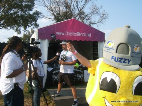 Beach Tennis mascot getting a pic while Scott Paschal gives interview
